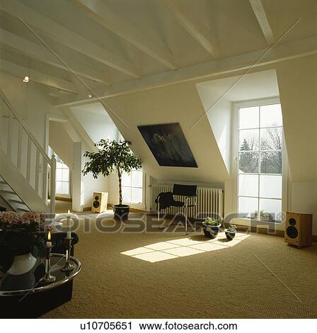 Stock Image - Cream carpet in uncluttered white attic living room. Fotosearch