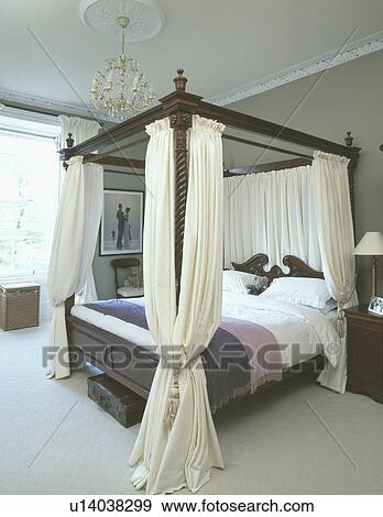 Cream curtains on fourposter bed in traditional bedroom with cream carpet View Large Photo Image Stock Photo - Cream curtains on fourposter bed in traditional bedroom with cream carpet. Fotosearch