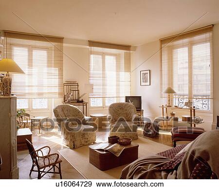 Stock Photo - Cream loosecovers on armchairs in traditional living room. Fotosearch