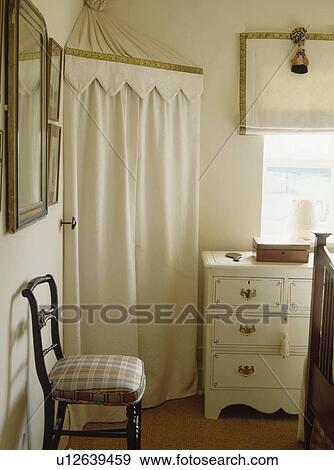 Stock Photo - Cream tented wardrobe in corner of neutral bedroom. Fotosearch