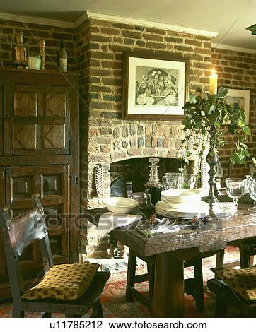 Crockery and cutlery on old oak table in country dining room View Large Photo Image Stock Image - Crockery and cutlery on old oak table in country dining room. Fotosearch