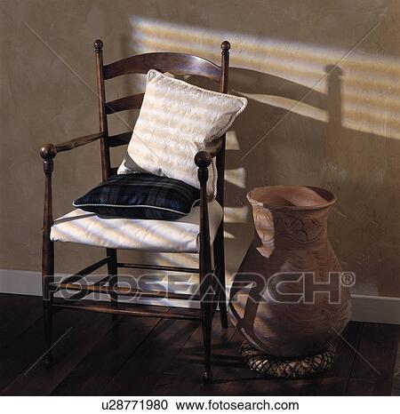 Cushions on antique wooden chair beside tall terracotta pot View Large Photo Image Stock Image - Cushions on antique wooden chair beside tall terracotta pot. Fotosearch