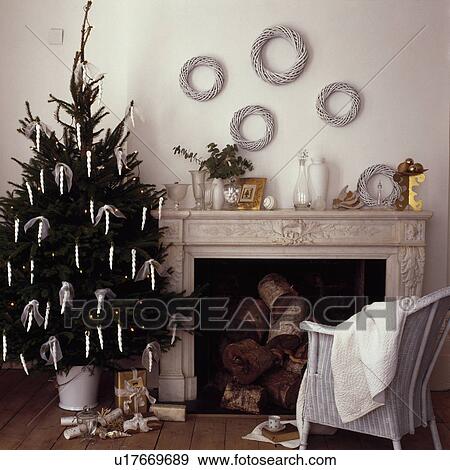 Stock Photo - Detail, contempory white room, white decorations on Christmas tree, white wreaths on wall above fire place . Fotosearch