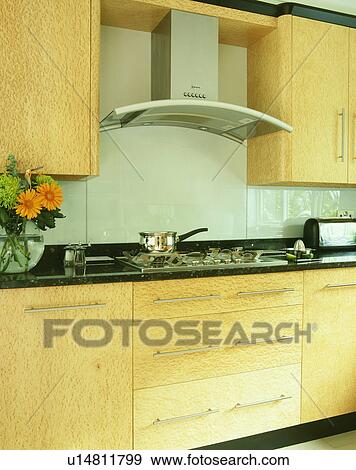 Stock Photo - Detail of contemporary wooden kitchen with extractor over hob.. Fotosearch