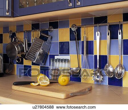 Detail of kitchen storage on blue and yellow tiled wall above wooden counter. View Large Photo Image Stock Photo - Detail of kitchen storage on blue and yellow tiled wall above wooden counter.. Fotosearch
