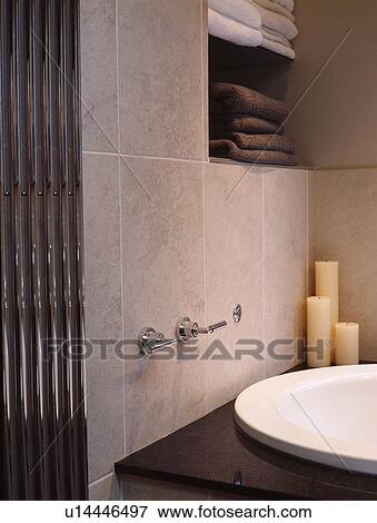 Stock Photo - Detail of tiled modern bathroom with towel storage. Fotosearch