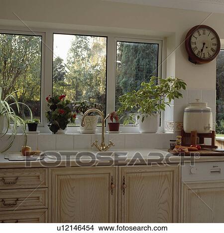 Picture - Double-glazed window above double white sink in pale wood kitchen. Fotosearch