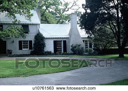 Stock Image - Drive and circular lawn in front of traditional house in the country. Fotosearch