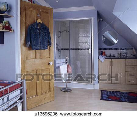 En suite shower area in a Child's blue bedroom under the eaves of a modern attic conversion View Large Photo Image Stock Photograph - En suite shower area in a Child's blue bedroom under the eaves of a modern attic conversion. Fotosearch