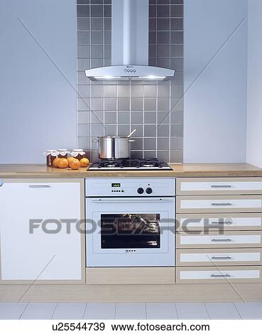 Extractor above pan on hob in modern kitchen with white oven View Large Photo Image Stock Photo - Extractor above pan on hob in modern kitchen with white oven . Fotosearch