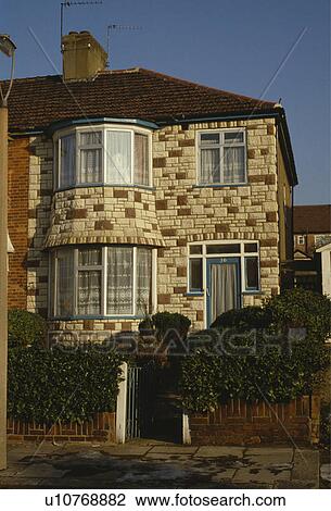 Stock Image - Fake stone-cladding on thirties semi-detached surburban house. Fotosearch