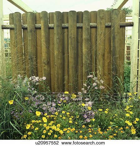 Stock Image - Fence in green country garden in summer. Fotosearch