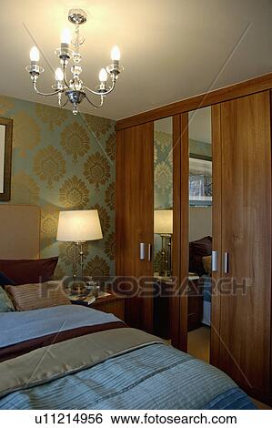 Fitted cupboards with mirror in modern bedroom with lighting lamp and ceiling light View Large Photo Image Stock Photograph - Fitted cupboards with mirror in modern bedroom with lighting lamp and ceiling light. Fotosearch
