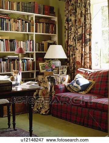 Stock Photo - Floral atterned curtains in traditional living room with red checked sofa. Fotosearch