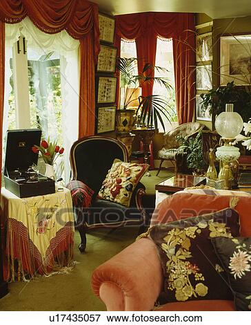 Floral Cushions On Armchairs In Edwardian Living Room With Red Curtains Stock Photo U17435057 Fotosearch