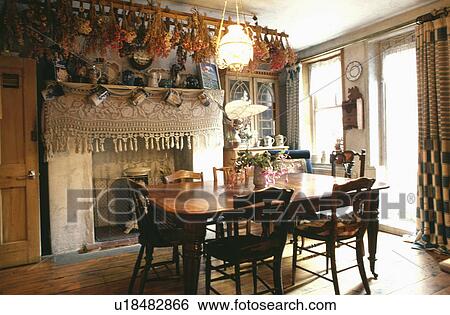 Flowers drying on rack above table and chairs in dining room with lace fabric on fireplace View Large Photo Image Stock Photograph - Flowers drying on rack above table and chairs in dining room with lace fabric on fireplace. Fotosearch