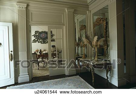 Picture - Fluted columns on either side of glazed double doors in traditional hall with antique console table. Fotosearch