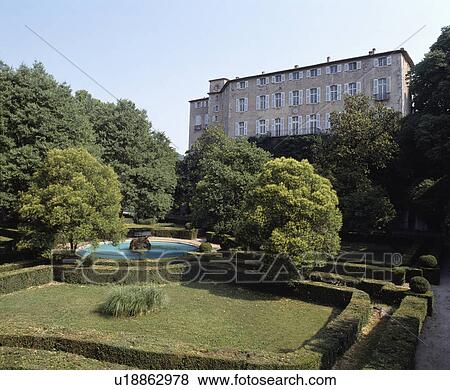 Stock Photo - Formal garden with clipped hedges in front of large traditional country house in France. Fotosearch