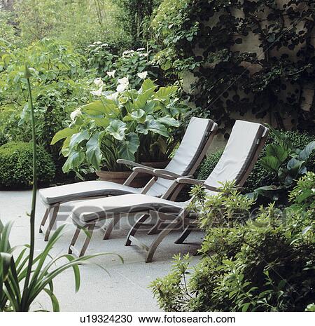 Stock Image - Furniture on patio in town garden in summer. Fotosearch