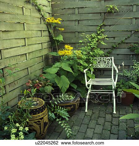 Stock Image - Furniture on patio in town garden in summer. Fotosearch