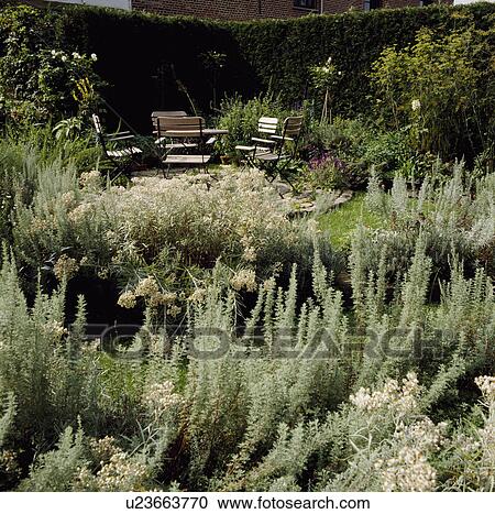 Stock Image - Furniture on patio in town garden in summer. Fotosearch