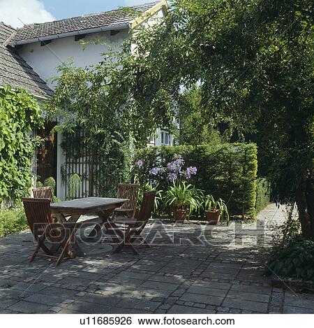 Furniture on patio in town garden in summer View Large Photo Image Stock Photograph - Furniture on patio in town garden in summer. Fotosearch