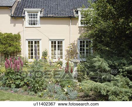 Garden border in front of traditional cream country house View Large Photo Image Stock Photo - Garden border in front of traditional cream country house. Fotosearch