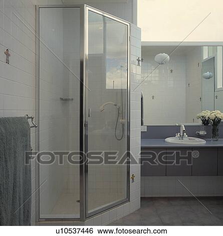 Stock Photograph - Glass shower cabinet in modern white and grey bathroom. Fotosearch