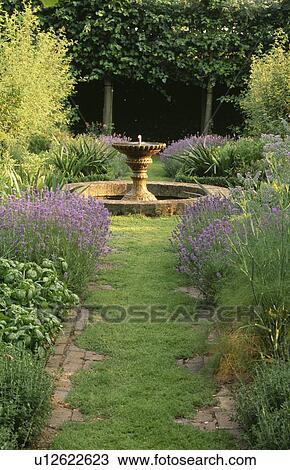Grass path leading through scented herbs to circular pond in country garden View Large Photo Image Stock Image - Grass path leading through scented herbs to circular pond in country garden. Fotosearch