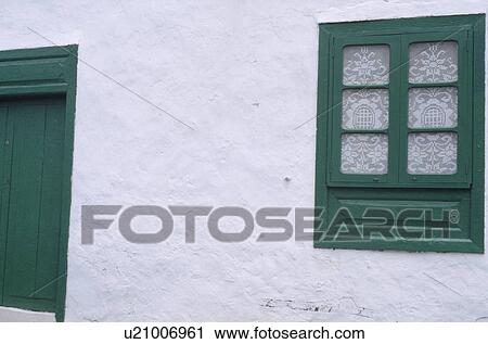 Stock Image - Green window and door in white cottage. Fotosearch