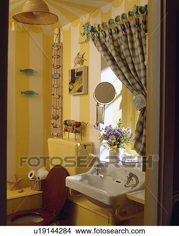 Picture - Green+yellow checked curtain above white basin in small bathroom with yellow striped wallpaper . Fotosearch