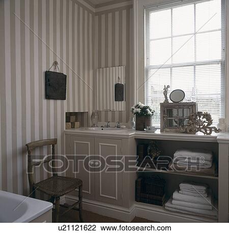 Grey and white striped wallpaper in townhouse bathroom with towels stored on open shelving in fitted unit View Large Photo Image Stock Image - Grey and white striped wallpaper in townhouse bathroom with towels stored on open shelving in fitted unit. Fotosearch