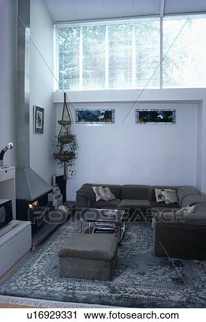 Stock Image - Grey corner sofa in modern white living room. Fotosearch