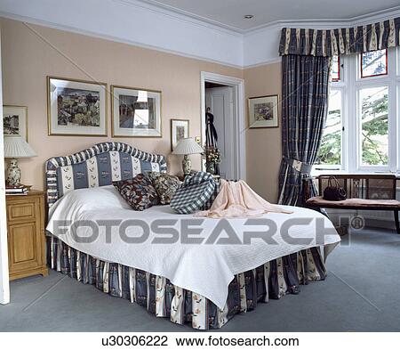 Grey striped and floral upholstered bed and vallance and matching curtains in traditional bedroom with grey carpet View Large Photo Image Stock Image - Grey striped and floral upholstered bed and vallance and matching curtains in traditional bedroom with grey carpet. Fotosearch