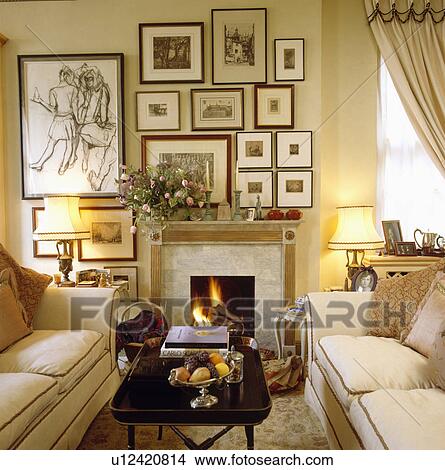 Group Of Pictures On Wall Above Fireplace In Traditional Living
