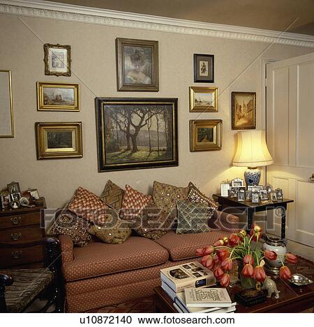 Group of pictures on wall above sofa in traditional living room View Large Photo Image Stock Image - Group of pictures on wall above sofa in traditional living room. Fotosearch