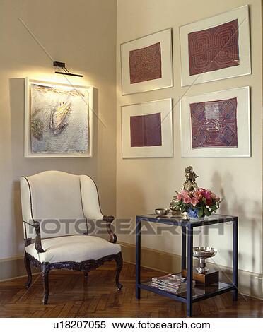 Stock Photography - Group of pictures on wall in traditional living room with white chair. Fotosearch