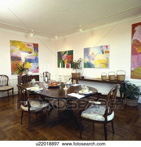 Holzern Parkettboden In Esszimmer Mit Antiker Oval Tisch Und Gross Abstrakt Bilder Auf Wande Unterhalb Spur Beleuchtung Stock Foto U22018897 Fotosearch