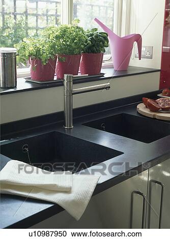 Herbs Growing In Pots On Windowsill Above Double Granite Sink With