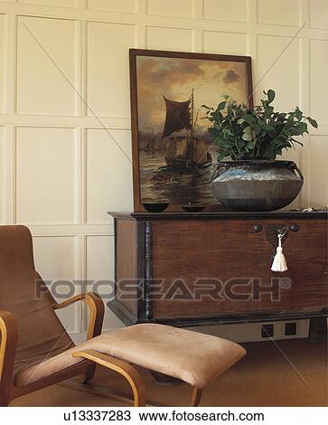 Houseplant and painting on antique chest in panelled living room with suede chaiselongue View Large Photo Image Stock Image - Houseplant and painting on antique chest in panelled living room with suede chaiselongue. Fotosearch