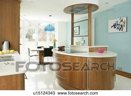 Island unit with white work top and fitted wood cupboards in modern turquoise kitchen dining room with white tiled floor View Large Photo Image Stock Image - Island unit with white work top and fitted wood cupboards in modern turquoise kitchen dining room with white tiled floor. Fotosearch