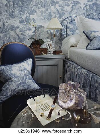 Jewellery and watch on table in hotel bedroom with blue+white wallpaper and cushion View Large Photo Image Stock Photograph - Jewellery and watch on table in hotel bedroom with blue+white wallpaper and cushion. Fotosearch