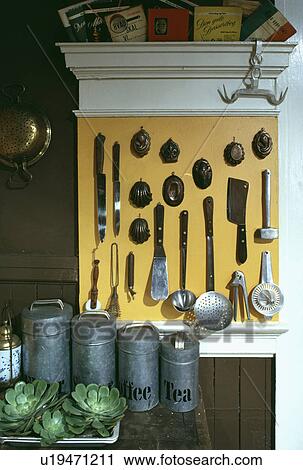 Knives and old metal jelly moulds on yellow panel above zinc storage tins and succulents View Large Photo Image Stock Image - Knives and old metal jelly moulds on yellow panel above zinc storage tins and succulents. Fotosearch