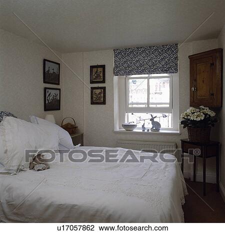 Lace trimmed pillows and bedcover in small white bedroom with blue+white blind View Large Photo Image Stock Image - Lace trimmed pillows and bedcover in small white bedroom with blue+white blind. Fotosearch