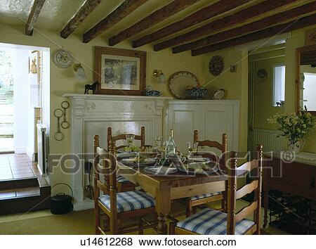 Stock Photo - Ladderback chairs and old pine table in cottage dining room with beamed ceiling. Fotosearch