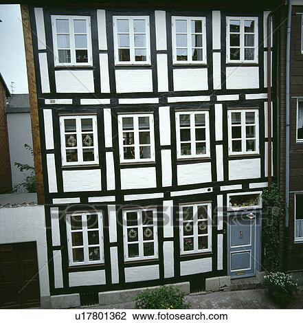 Stock Image - Large black+white traditional terraced town house in Germany. Fotosearch