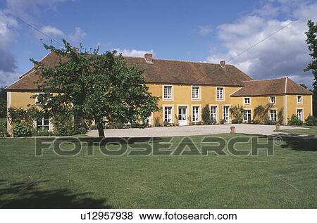 Stock Photo - Large country house with side extensions and lawn in front. Fotosearch