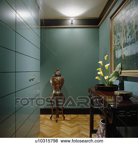 Large oriental vase on stool in blue-green modern hall with parquet floor and mahogany console table View Large Photo Image Stock Photo - Large oriental vase on stool in blue-green modern hall with parquet floor and mahogany console table. Fotosearch