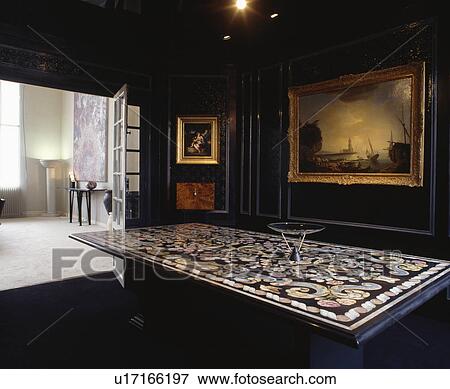 Large painting on black panelled wall in dining room with ornately inlaid table View Large Photo Image Stock Photo - Large painting on black panelled wall in dining room with ornately inlaid table. Fotosearch