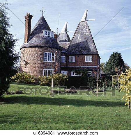 Stock Image - Lawn in front of traditional oasthouse conversion. Fotosearch